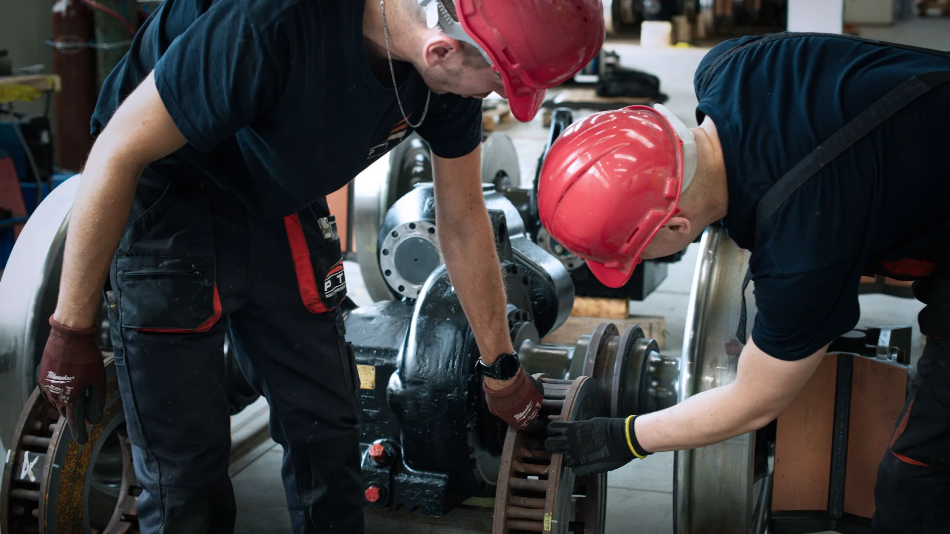 Dwóch serwisantów przy zestawie kołowym w hali PTS